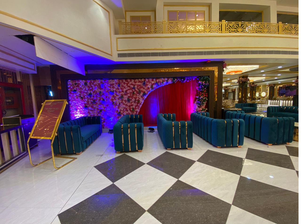 Royal teal velvet lounge with floral stage backdrop and purple mood lighting at The Great Palace Banquet Hall